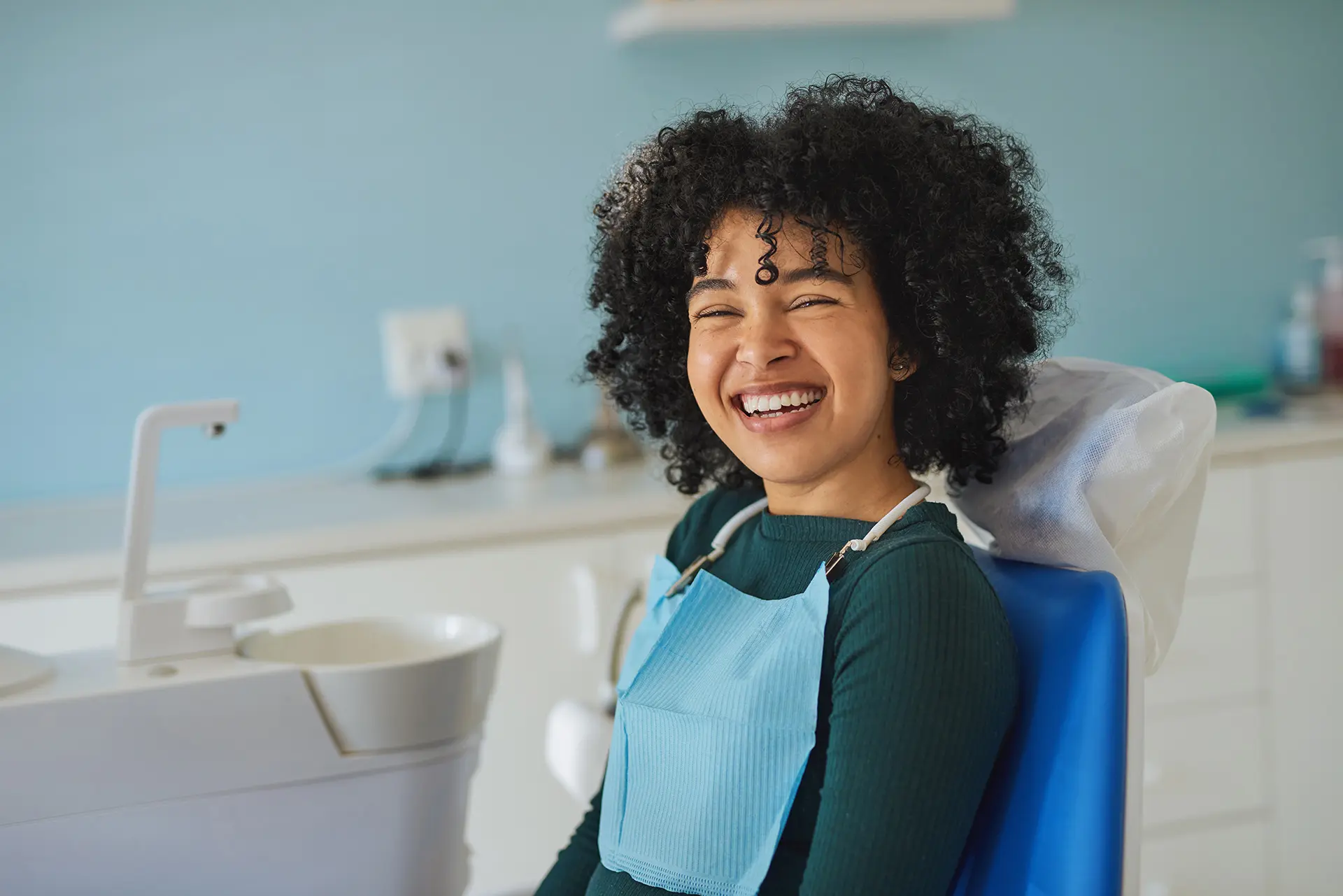 Happy young woman sitting in a dentist’s chair