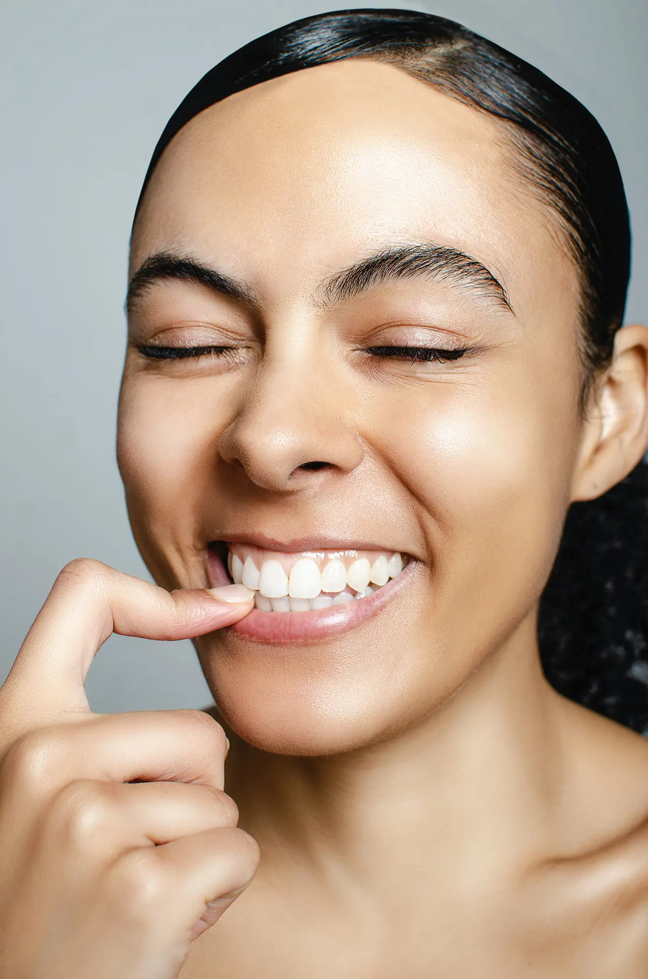 Person pointing to their pearly white smile